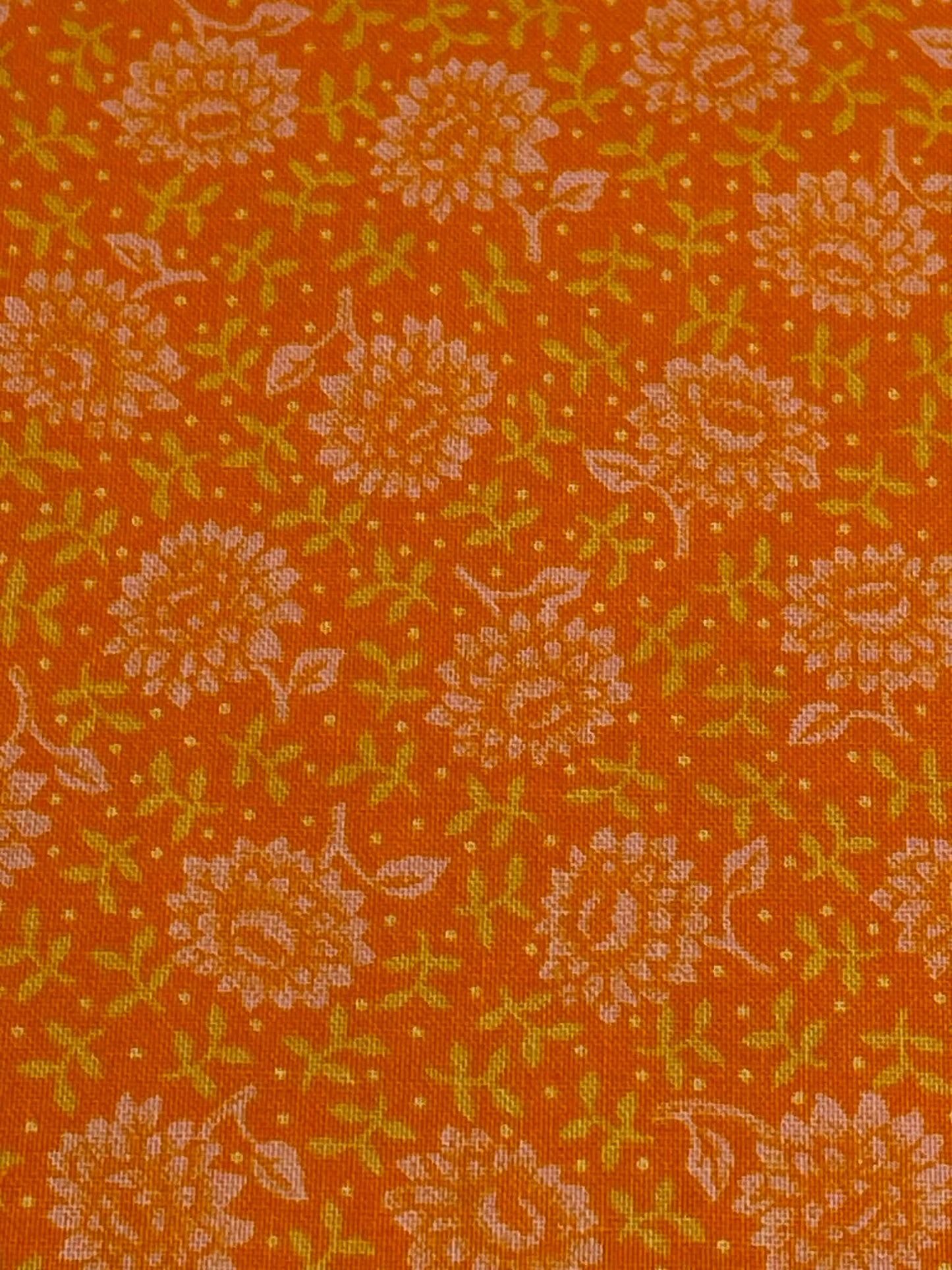 Orange and white flowers on orange background. Sold by the half yard.