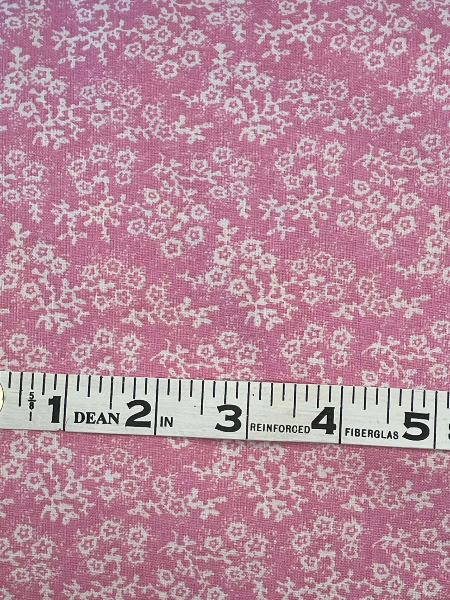 White floral calico on pink background. Sold by the yard.