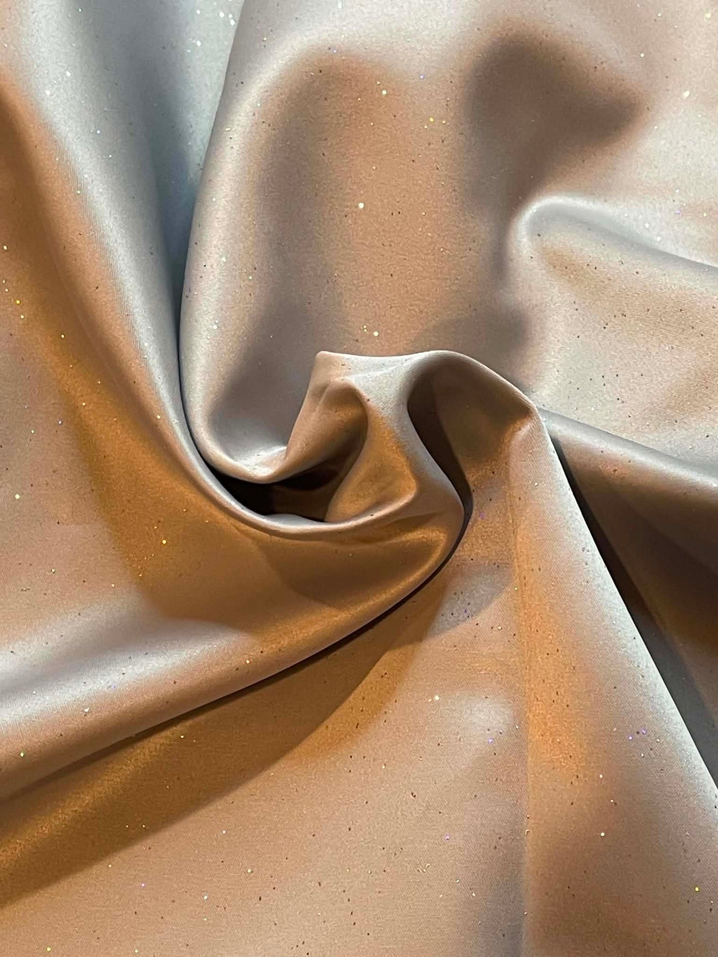 Gray satin with multi-colored sparkles throughout.  Sold by the yard.