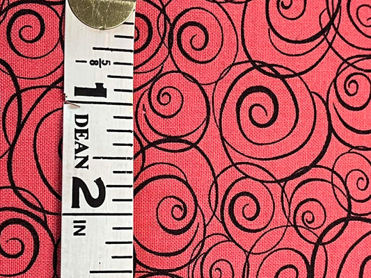 black swirls on salmon colored background.  Sold by the yard.