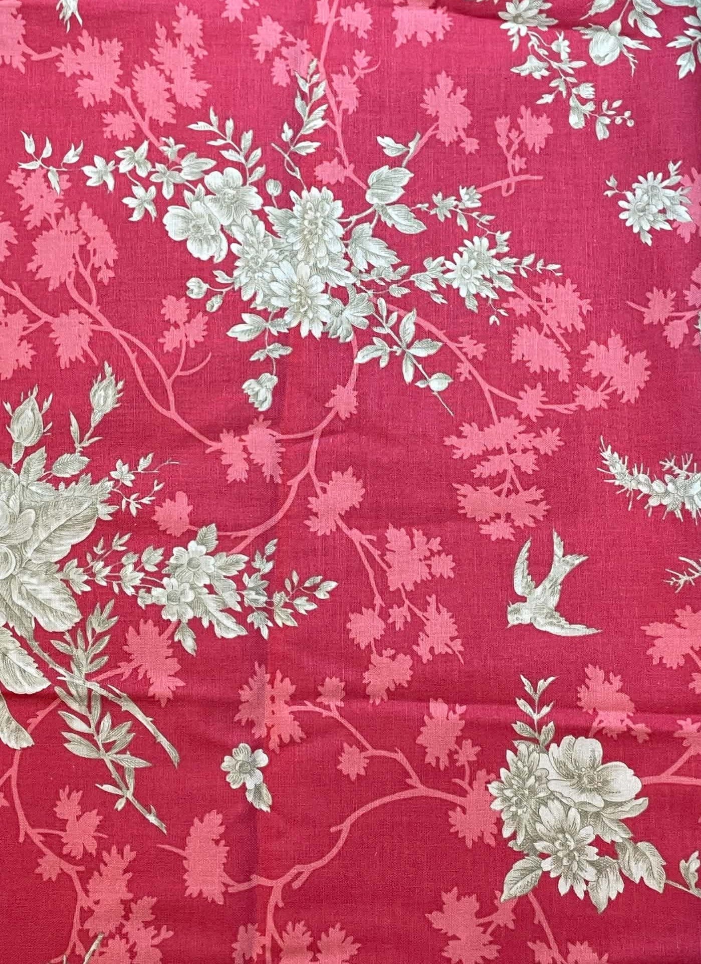 Notting Hill.  Tan floral on muted red background.  Sold by the yard.