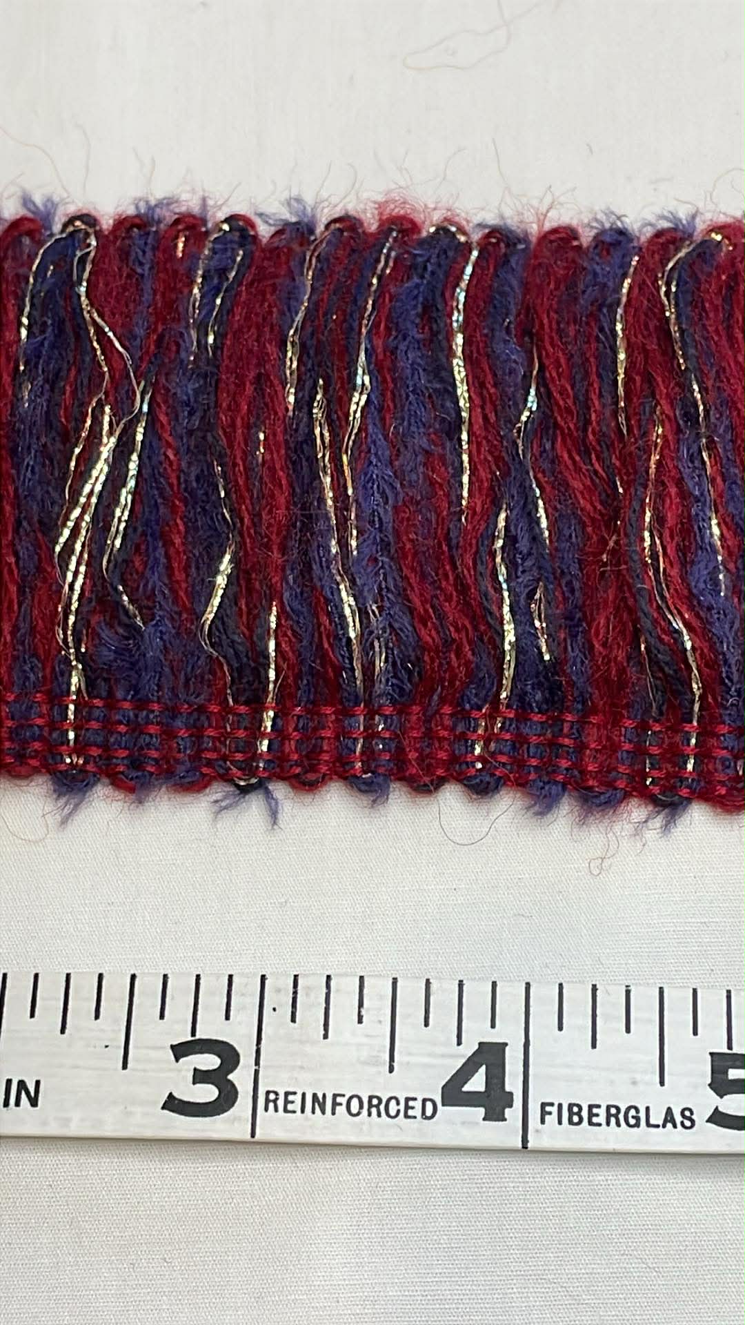 2 1/2" wide maroon, blue and metallic brush yarn chainette trim.  Sold by the half yard.