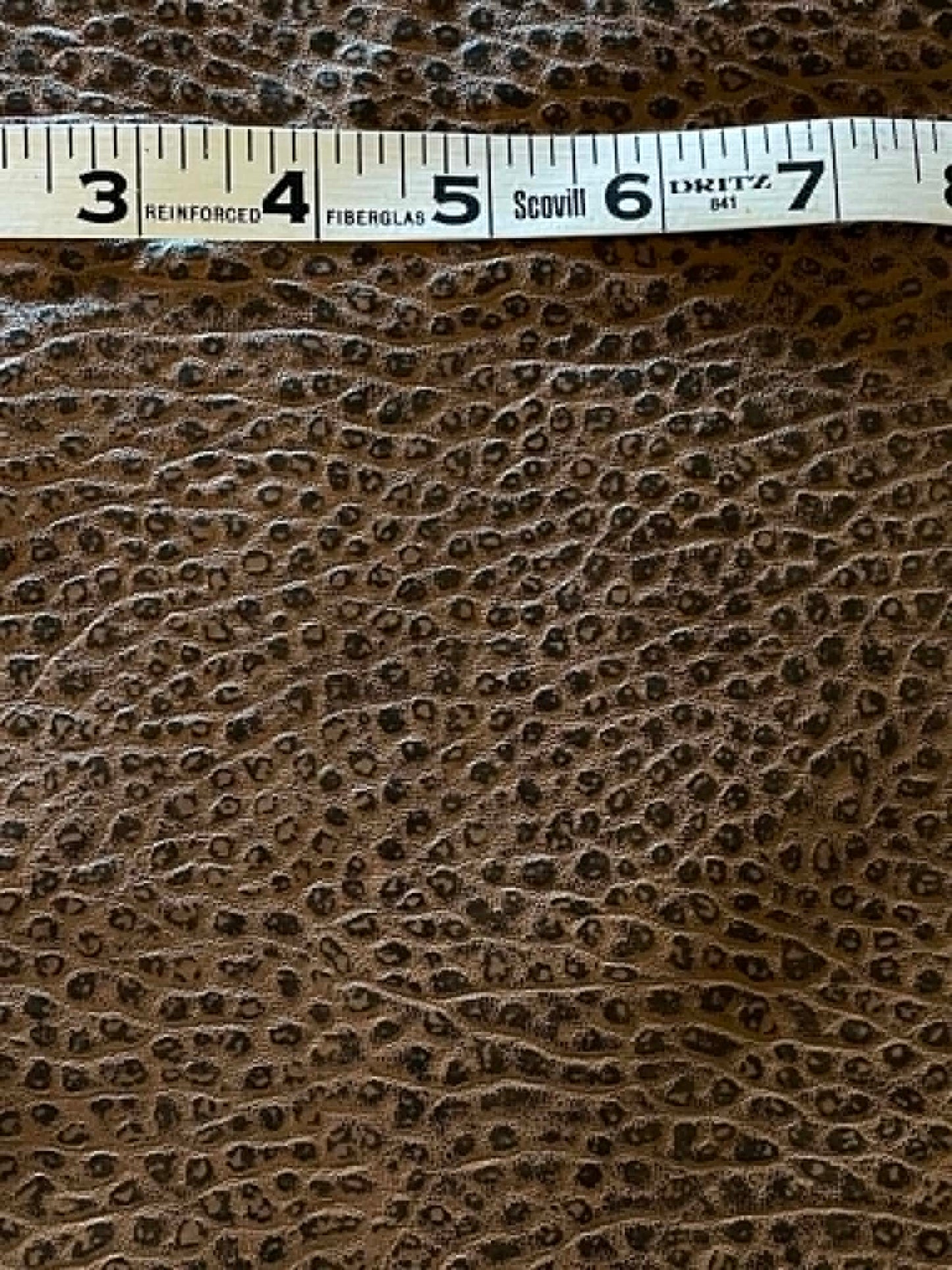 Remnant.  Black and brown embossed hide fabric.