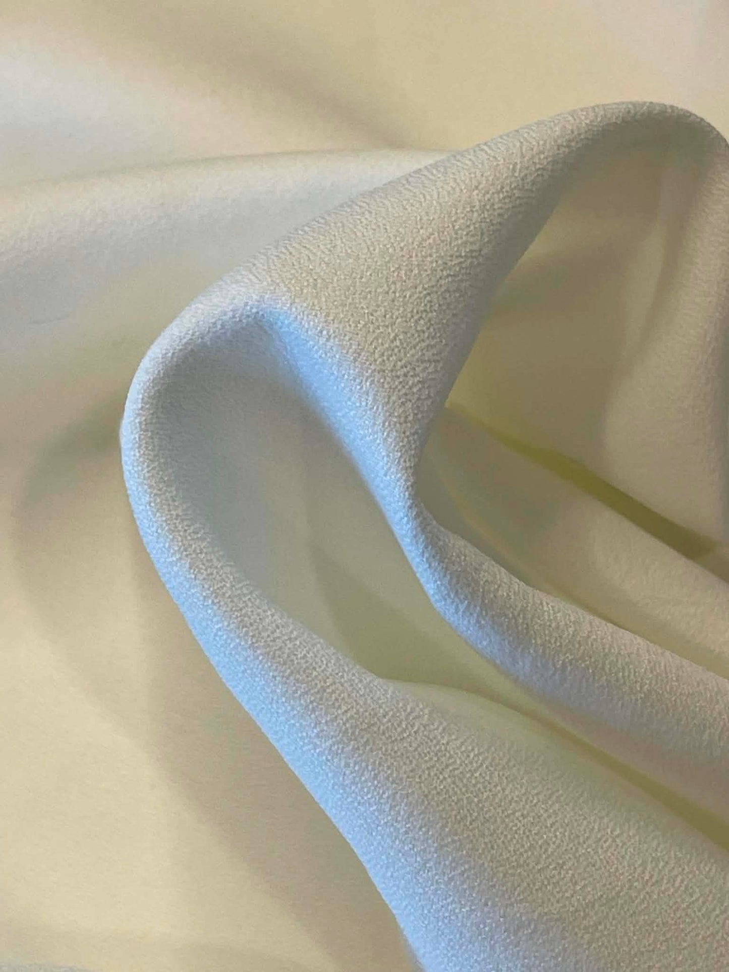Off white polyester crepe.  Sold by the yard.