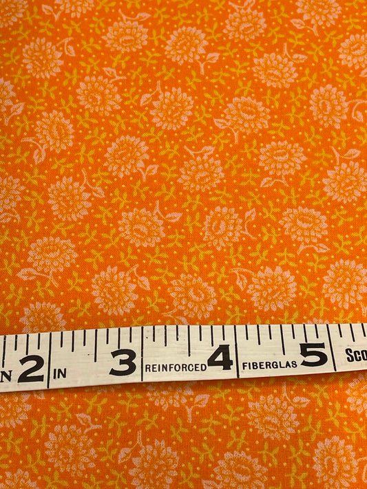 Orange and white flowers on orange background.  Sold by the half yard.