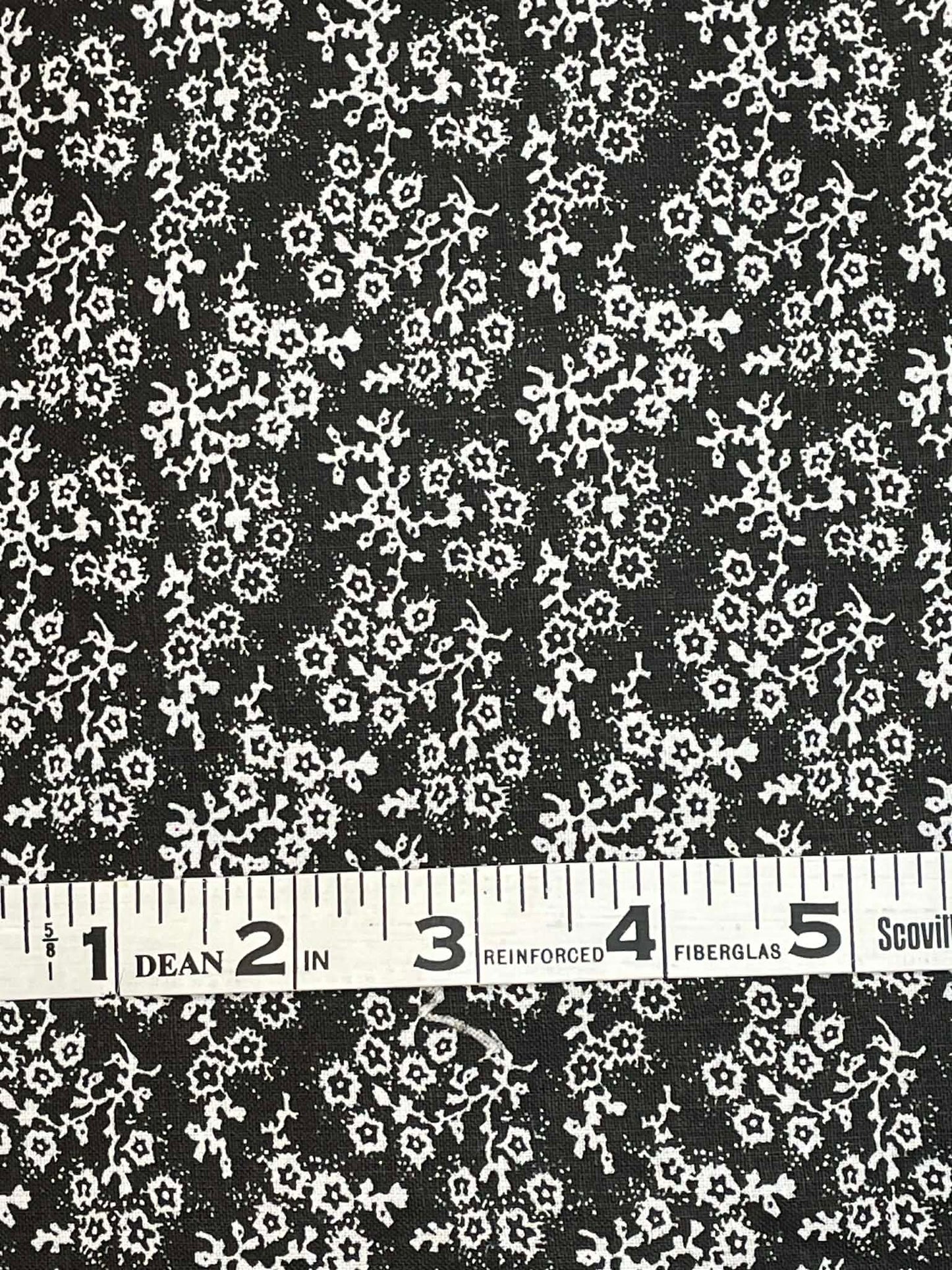 White floral calico on black background.  Sold by the yard.