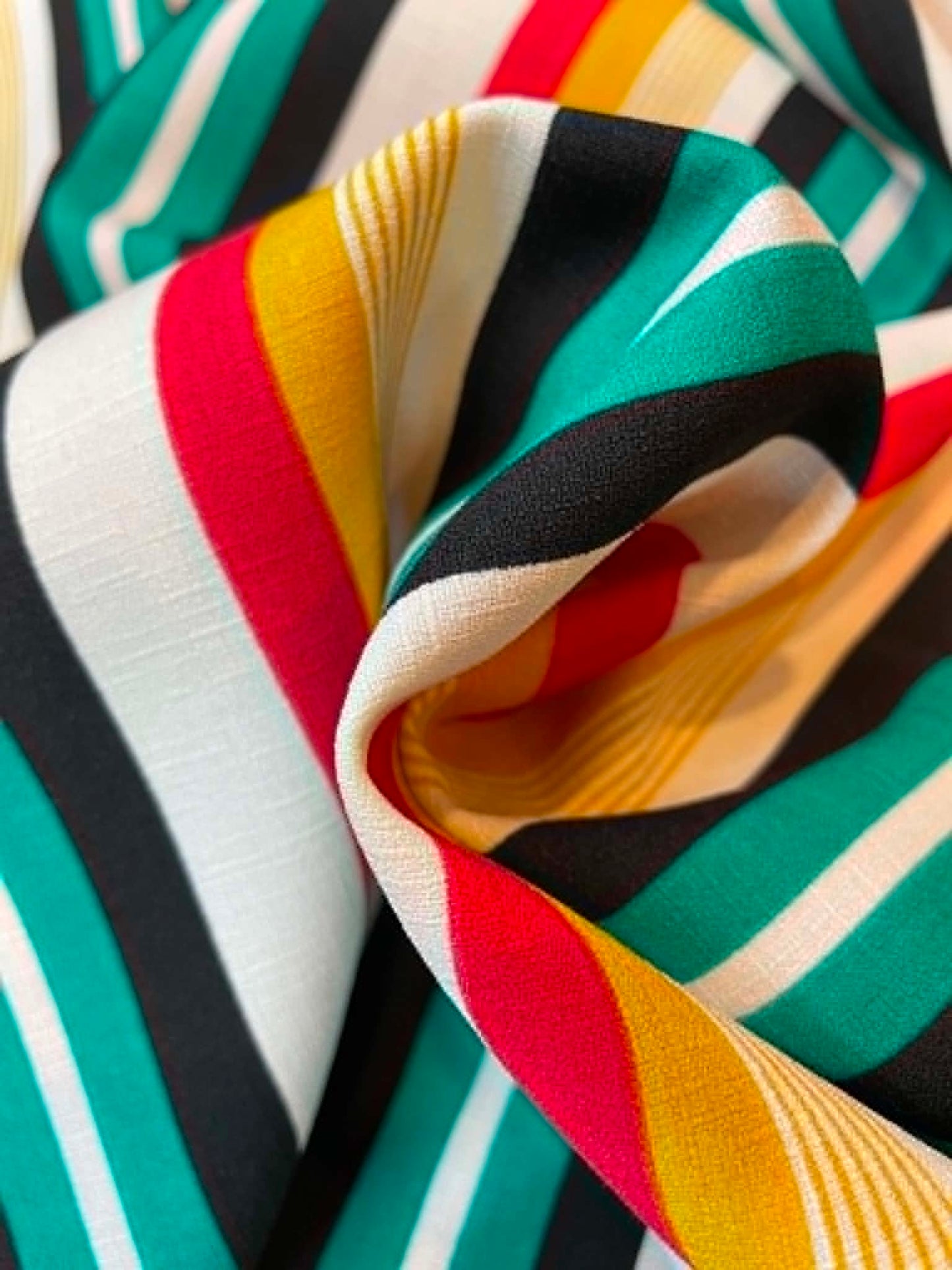 Green, red, yellow, black and white stripes.  Polyester crepe.  ** REMNANT **