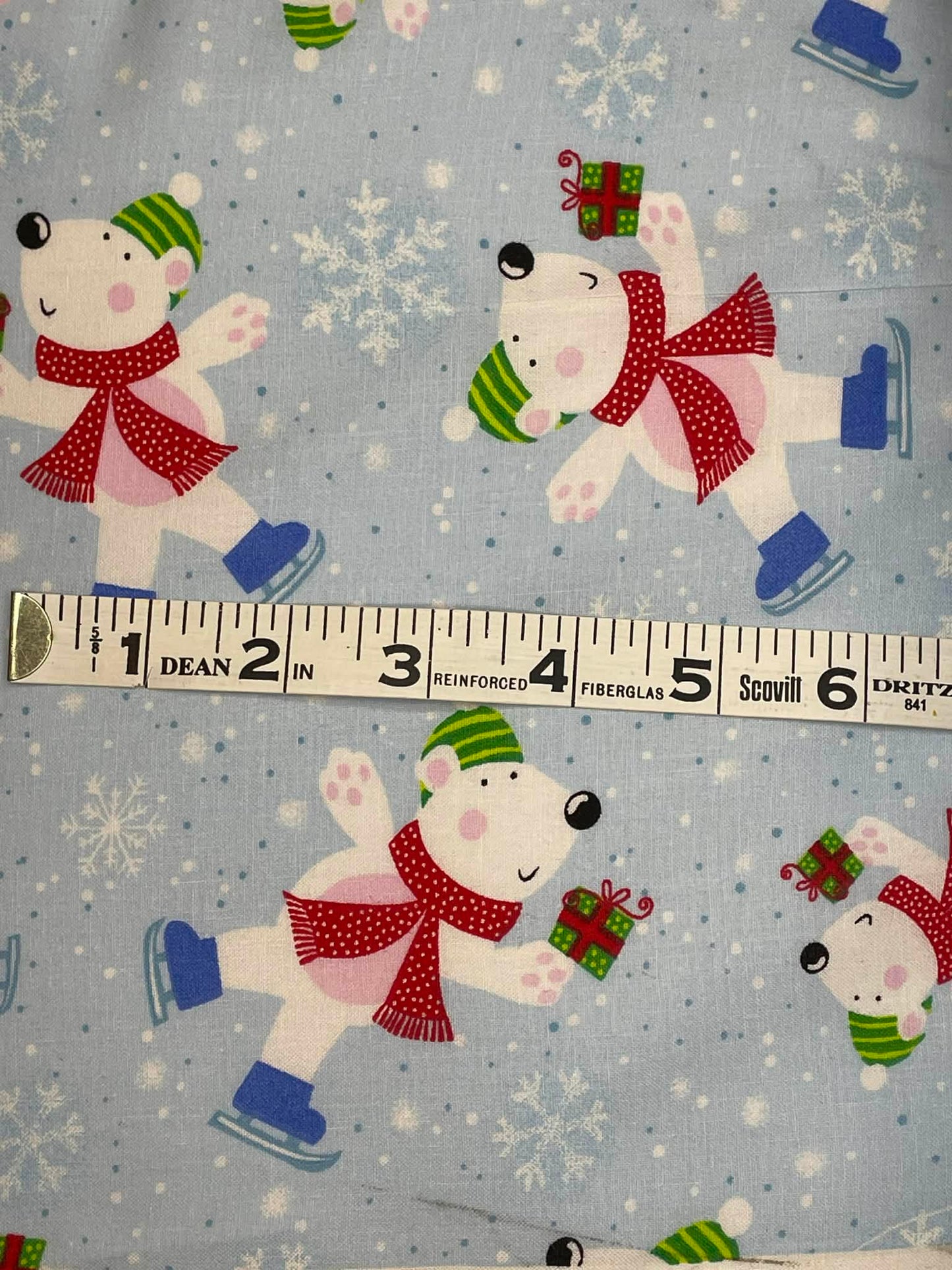 Polar bear on ice skates on blue background.  Sold by the yard.