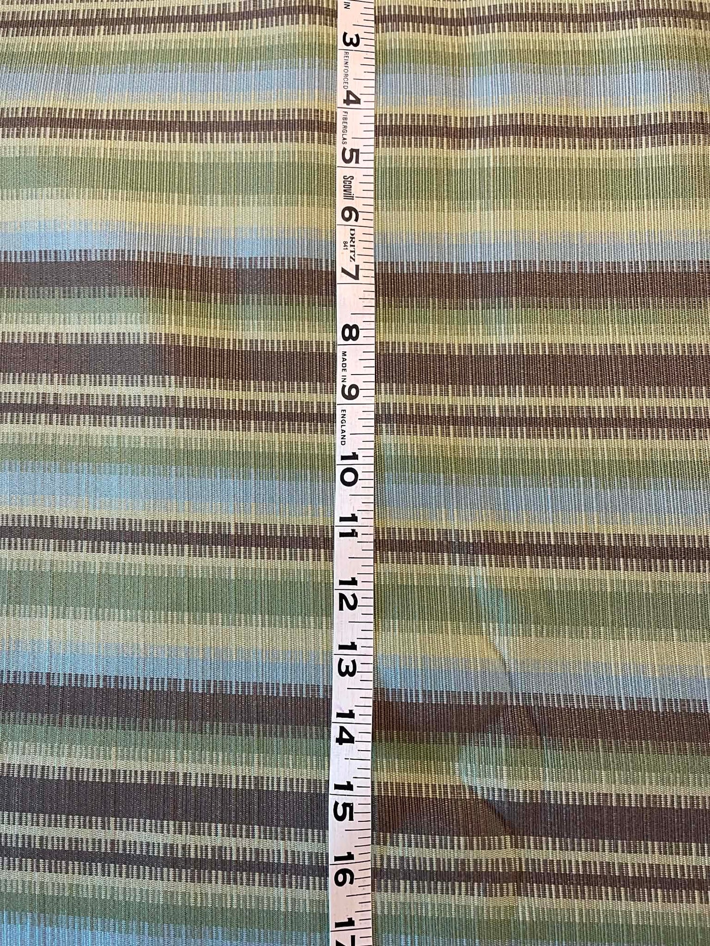 Green, blue and brown stripes.  Heavy upholstery fabric.  Sold by the yard.