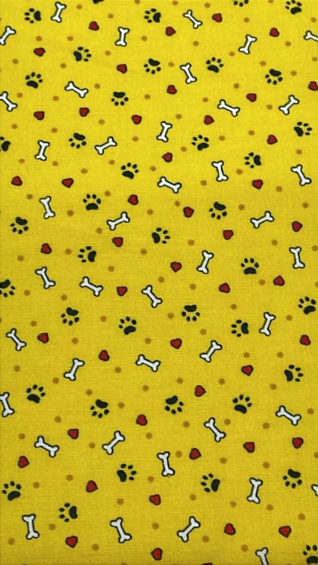 Black paw prints, white bones and red hearts on yellow background.  Sold by the half yard.