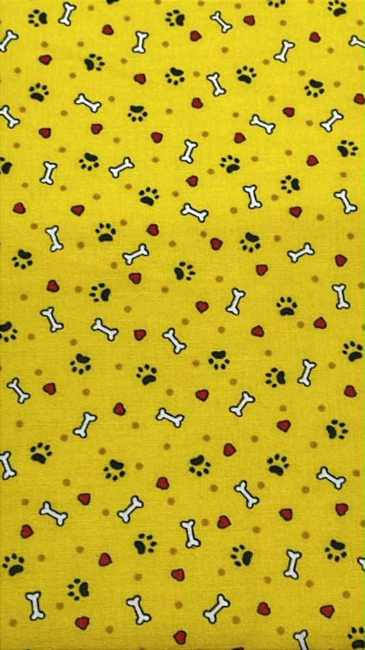 Black paw prints, white bones and red hearts on yellow background.  Sold by the half yard.
