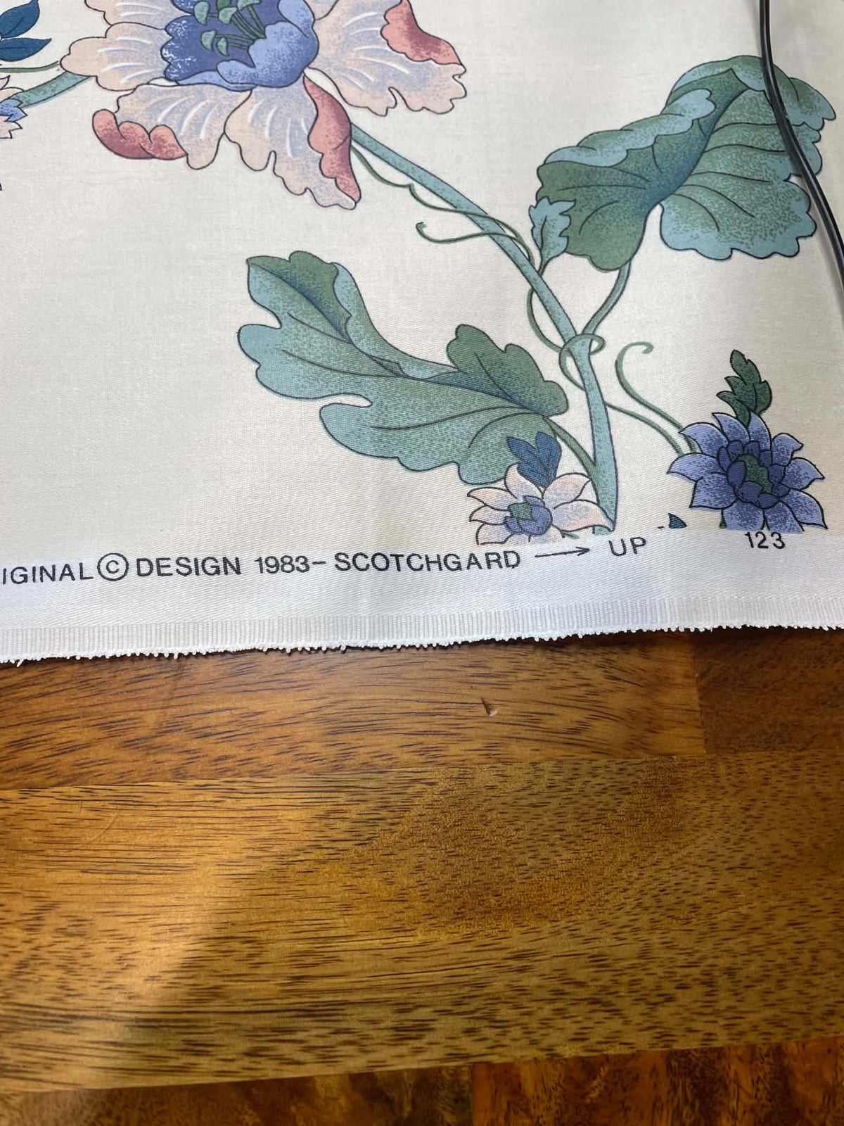 Blue, green and peach floral on white.  Upholstery fabric.  Sold by the yard.