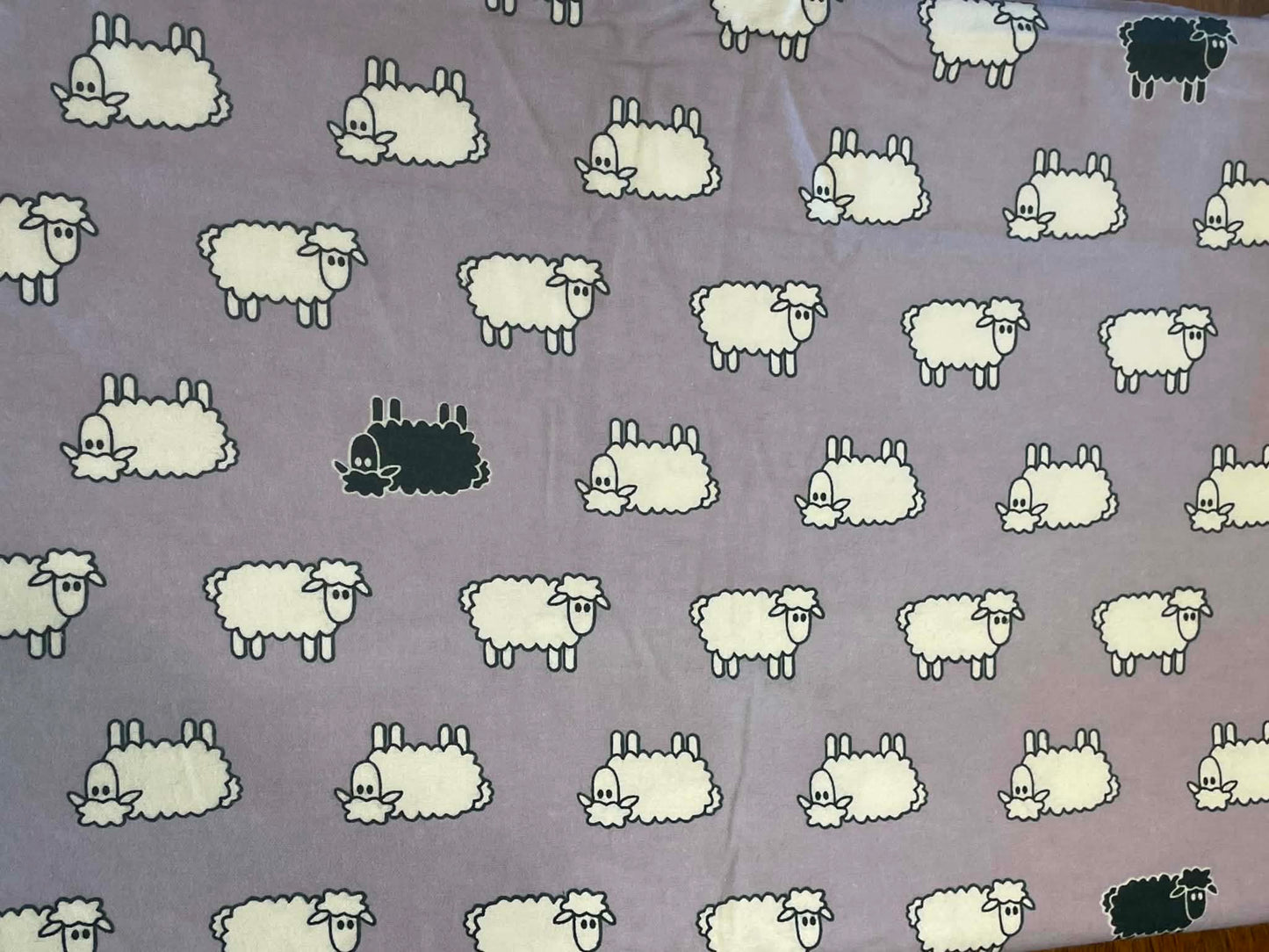 Flannel.  Sheep on lavender background.  Sold by the half yard.