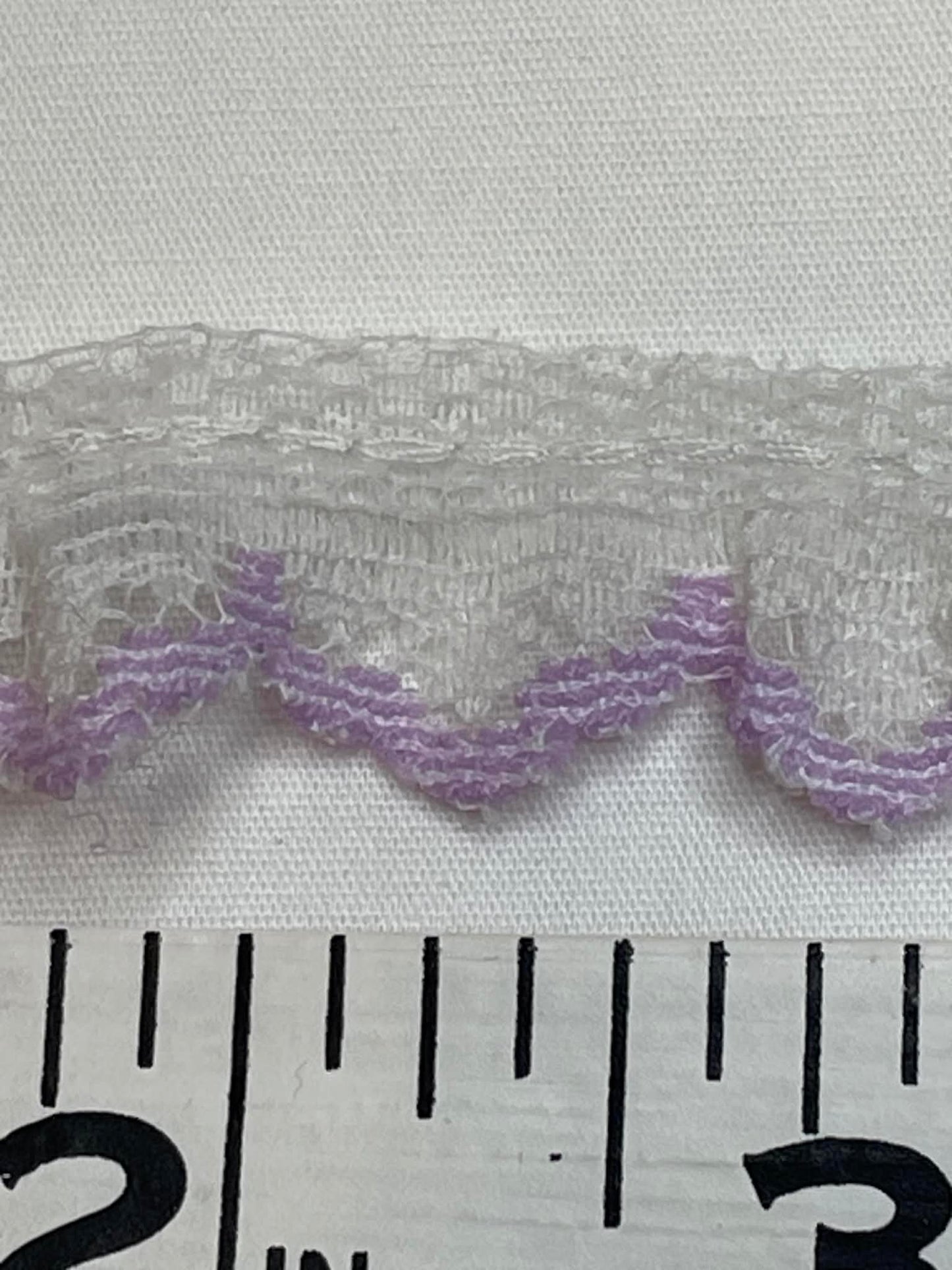 1/5" wide.  White and lavender lace trim.  Sold by the yard.