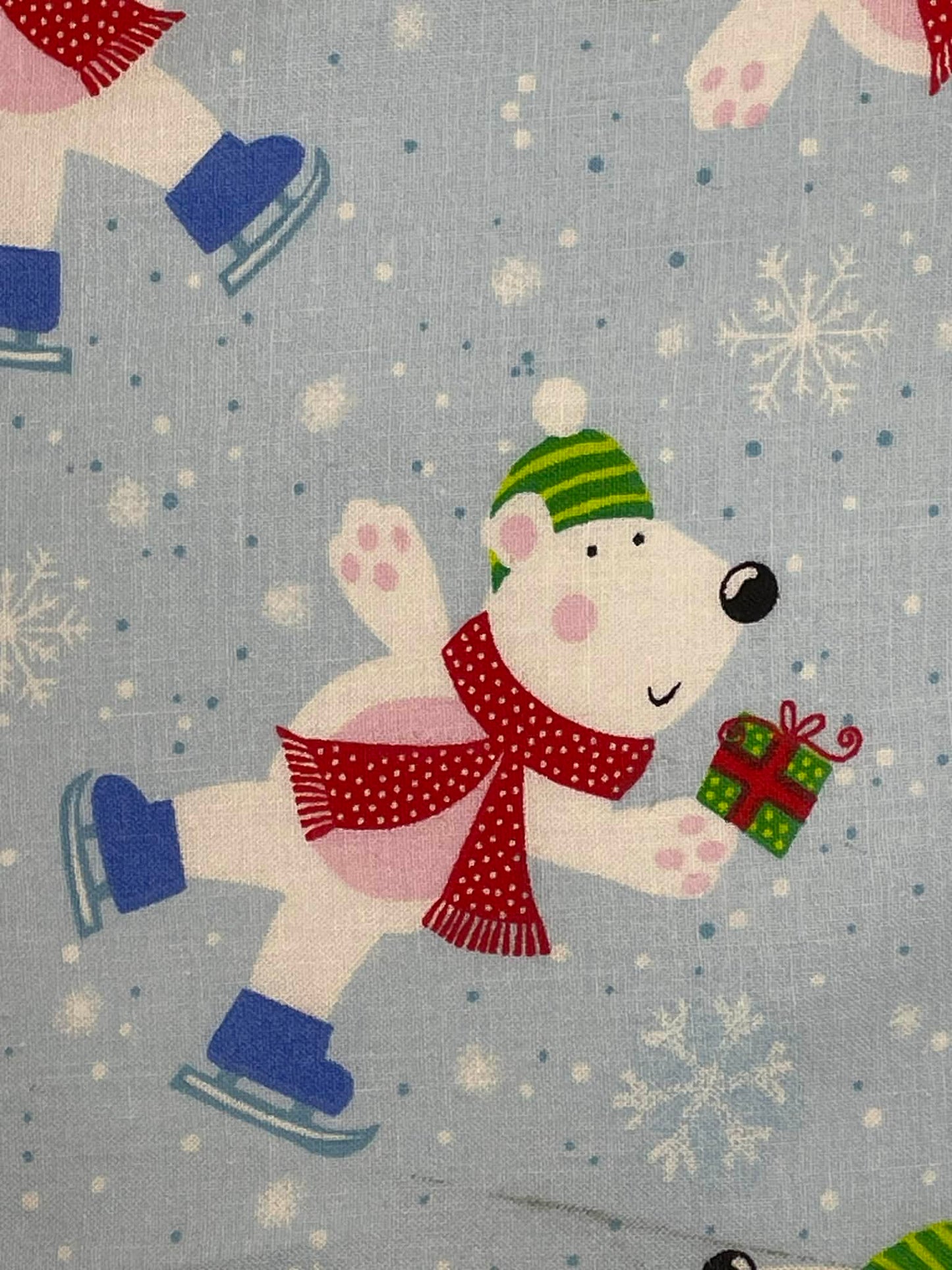 Polar bear on ice skates on blue background.  Sold by the yard.