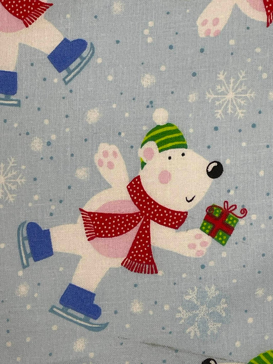 Polar bear on ice skates on blue background.  Sold by the yard.