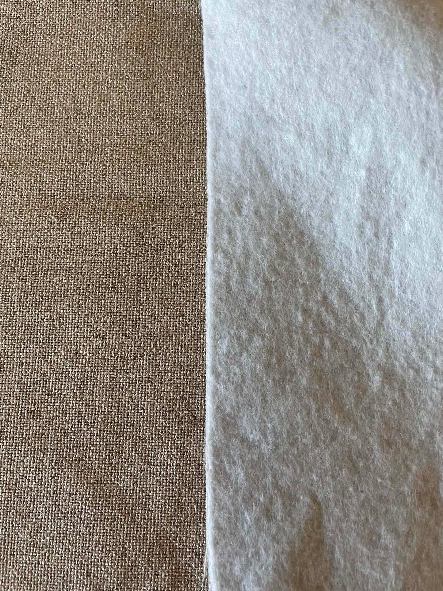 Grayish, off white upholstery fabric with white felt backing.  Sold by the half yard.