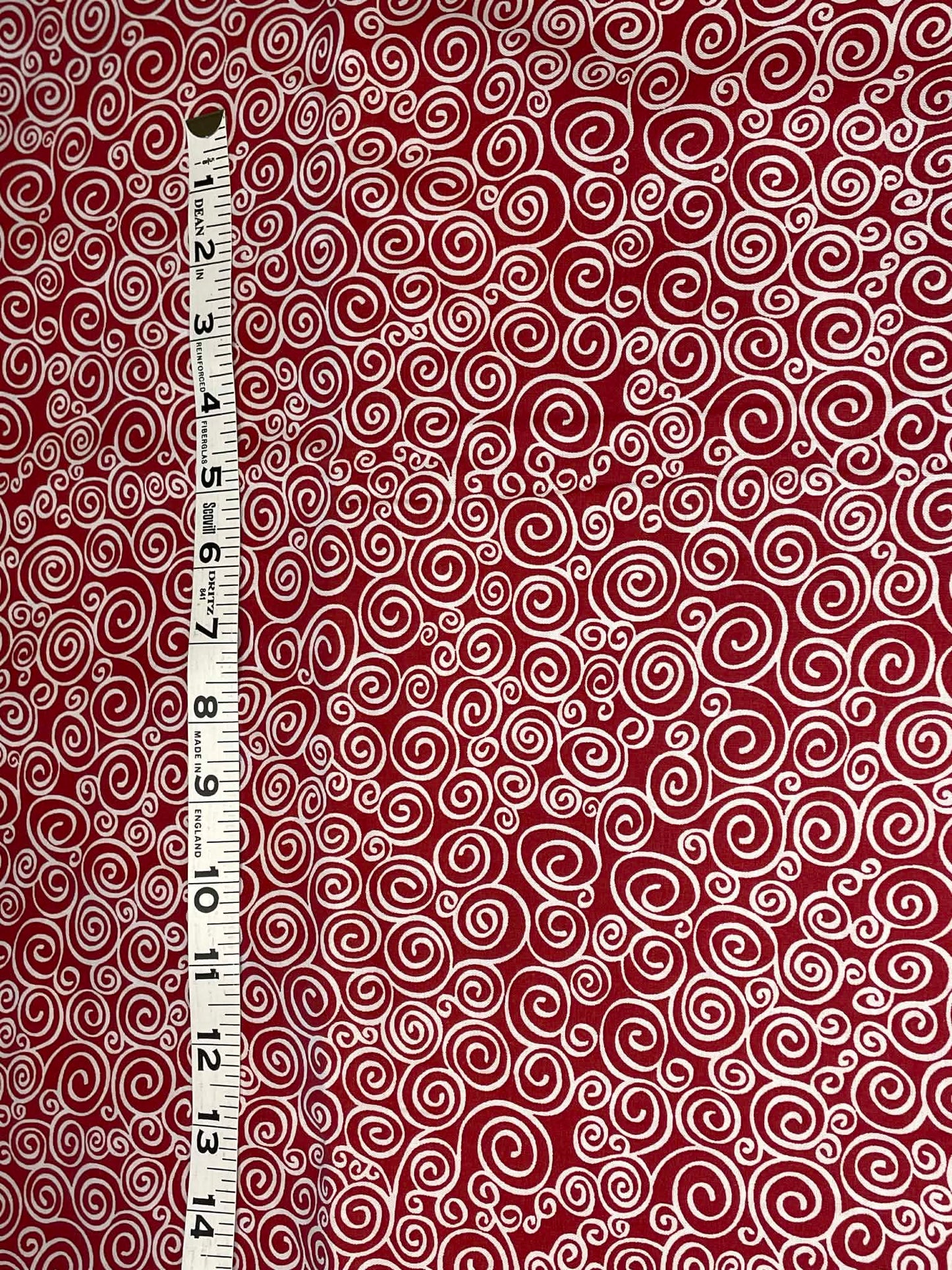White swirls on red background - Sold by the 1/2 yard.